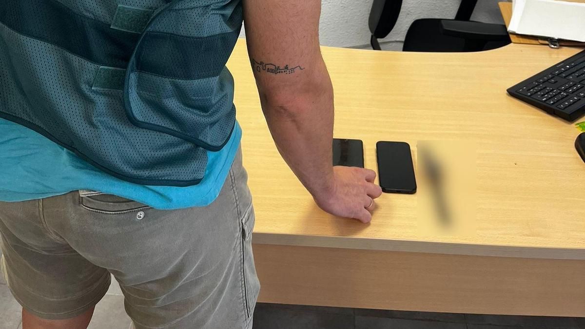 Un guardia civil, con los dos móviles incautados.