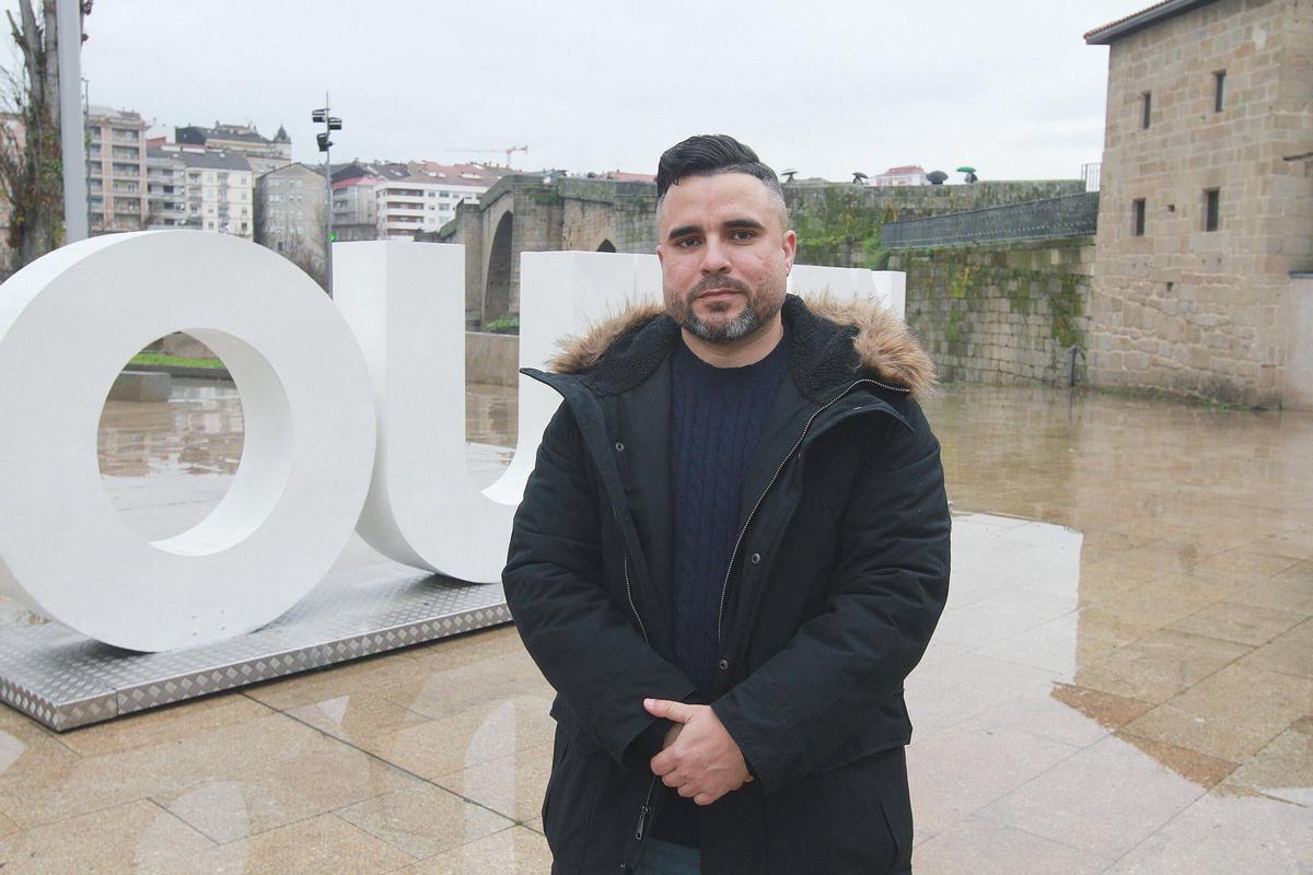 Luis, junto al letrero turístico de Ourense en el entorno del Puente Romano.