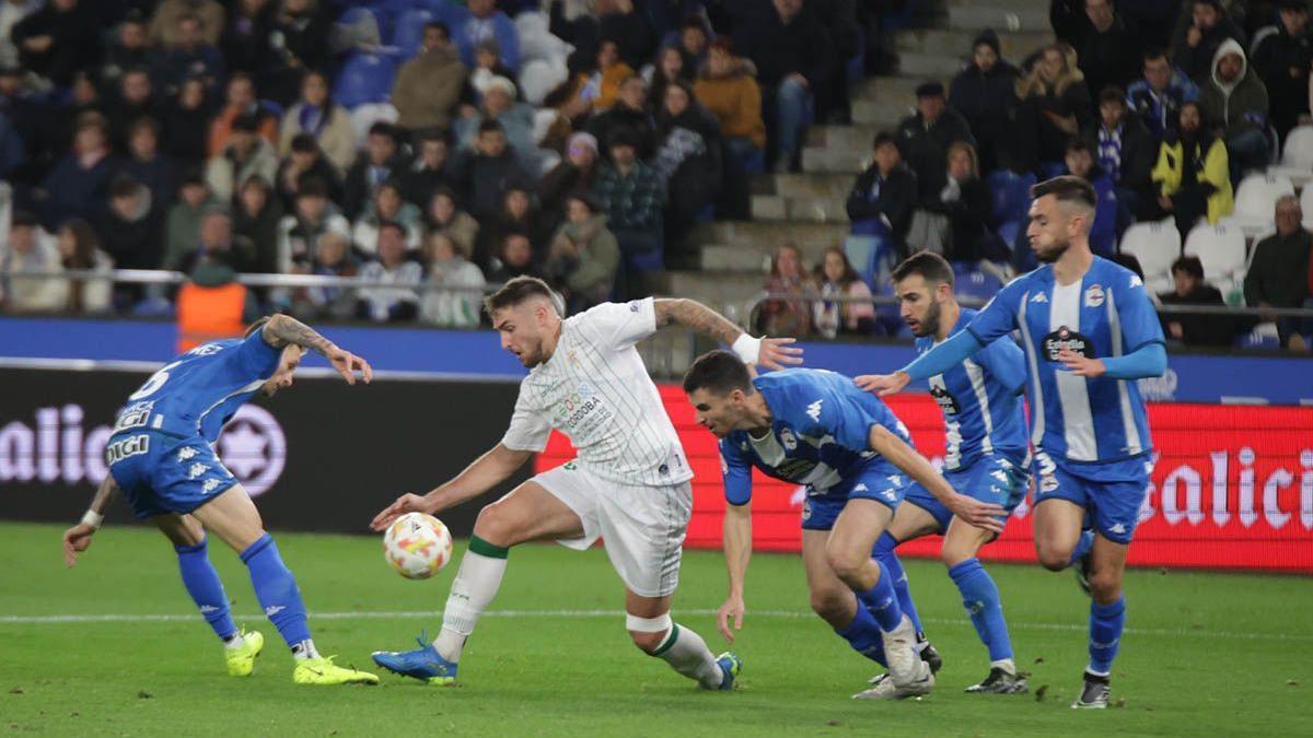 Casas, entre rivales del Deportivo, en el encuentro de la primera vuelta, en Riazor.