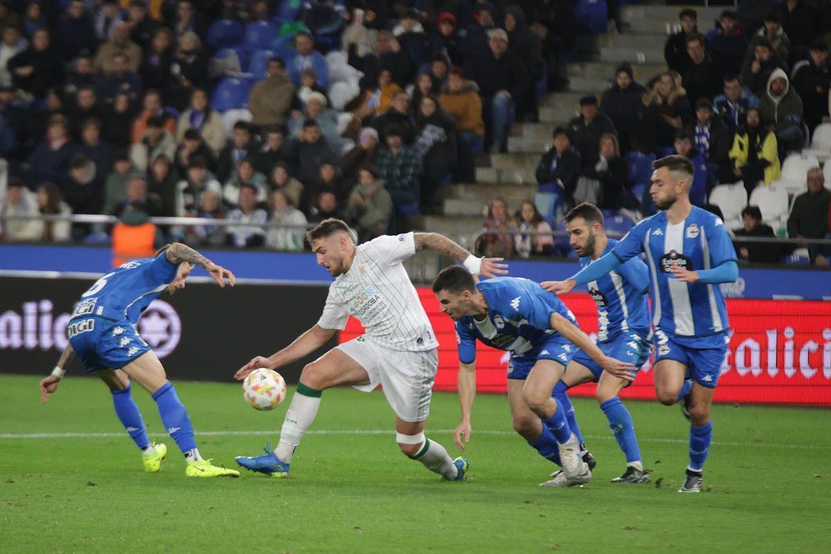 Casas, entre rivales del Deportivo, en el encuentro de la primera vuelta, en Riazor.