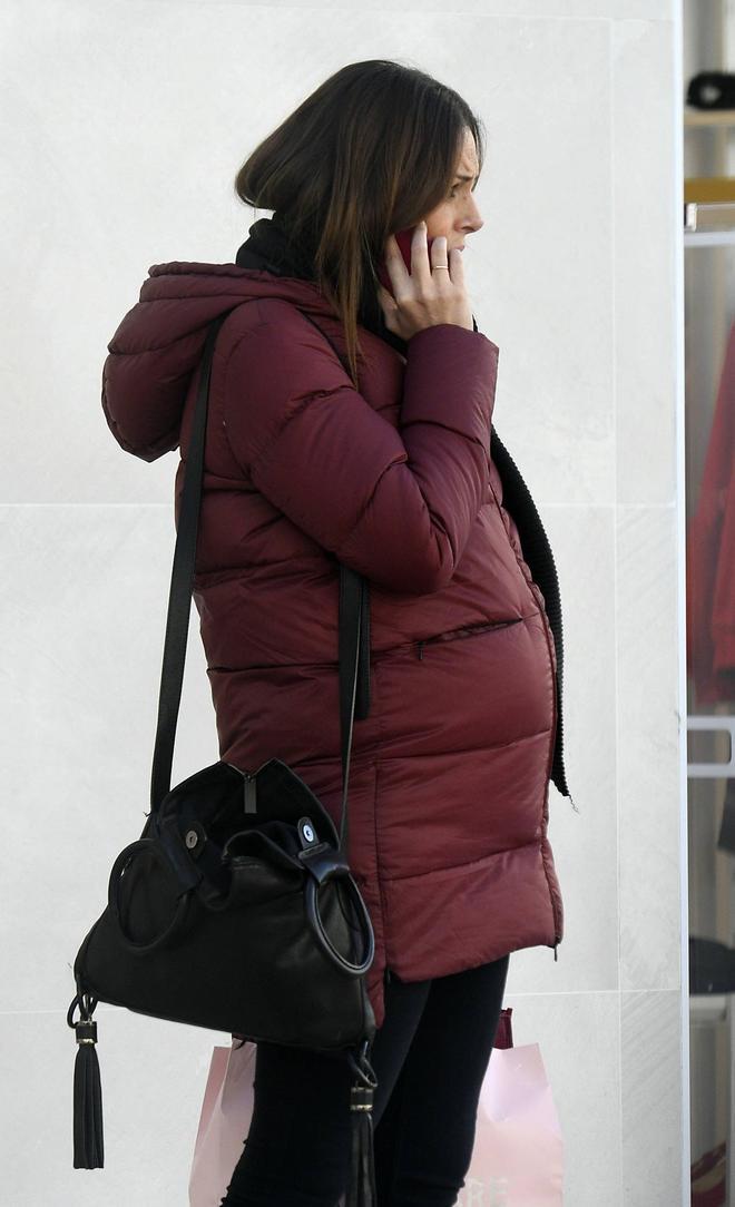 Eva González embarazadísima con un chaquetón granate