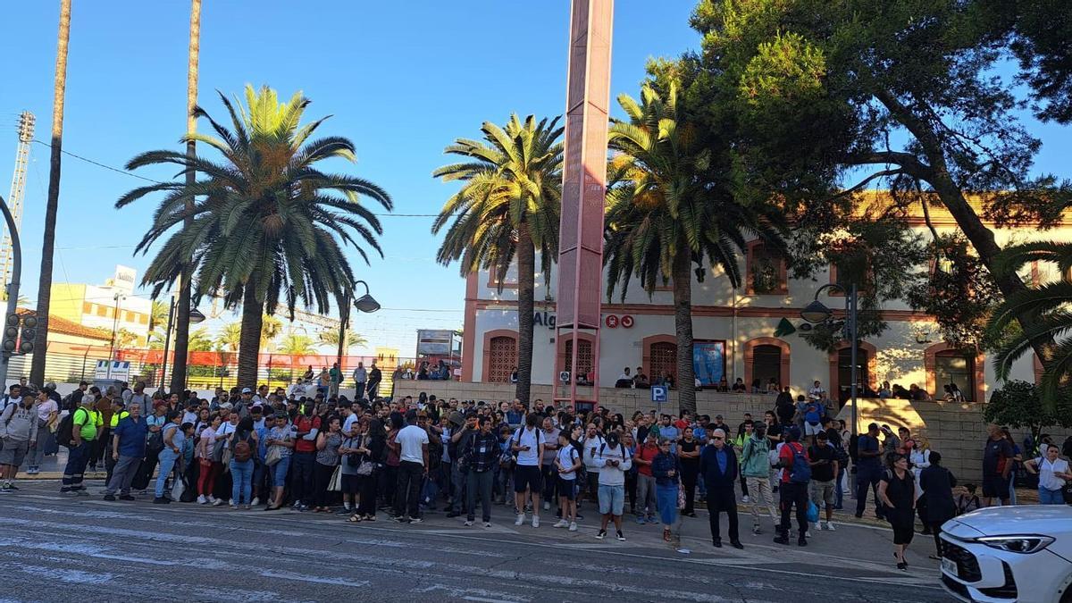 Viajeros esperan el autobús alterntivo en la explanada de acceso a la estación de Algemesí este lunes.