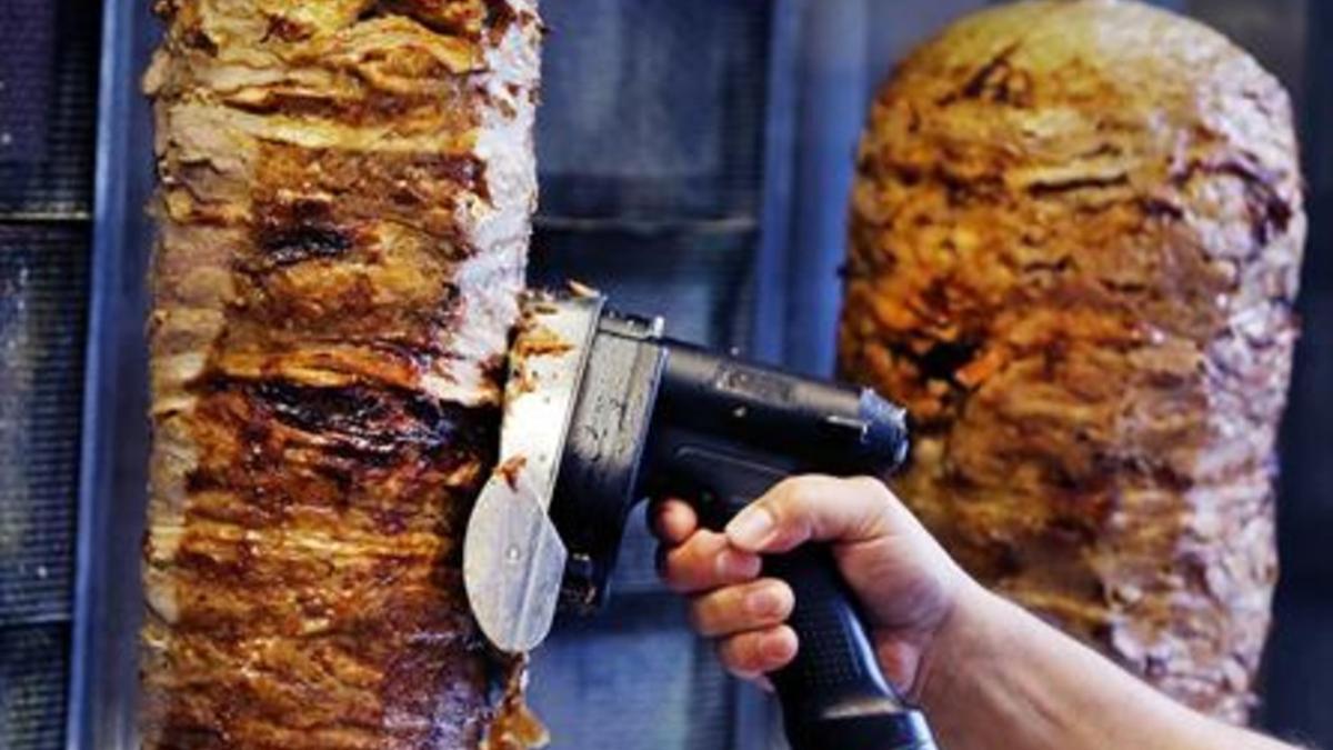 Un hombre corta carne de kebab en un establecimiento de Fráncfort.