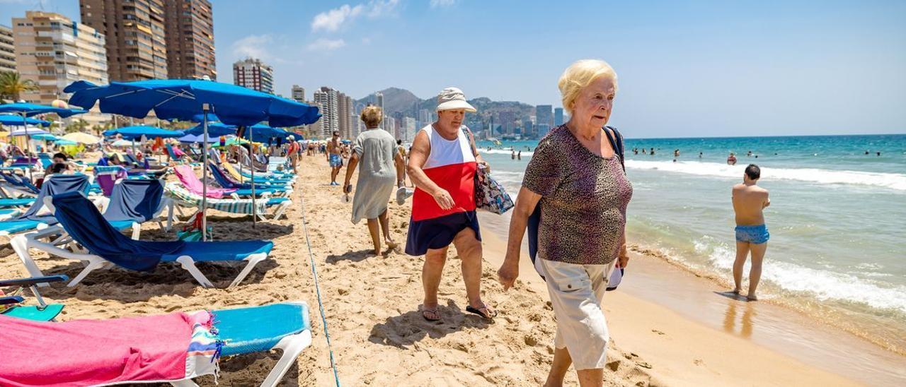 Dos señoras pasean por la playa de Levante de Benidorm la pasada primavera.