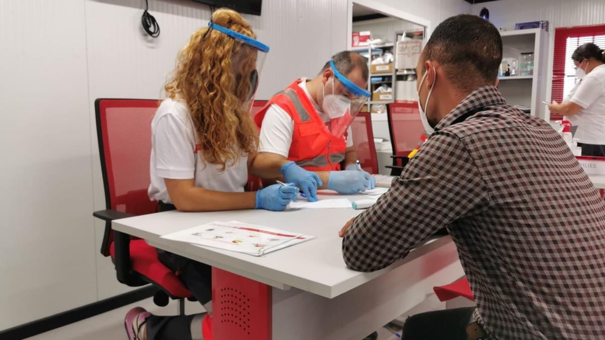 Voluntarios de Cruz Roja atienden a una persona rescatada de una patera.