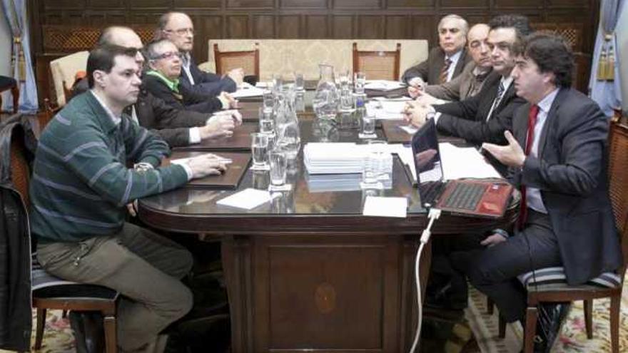 Representantes vecinales y de la hostelería, a la izquierda, reunidos ayer con los concejales. / la opinión