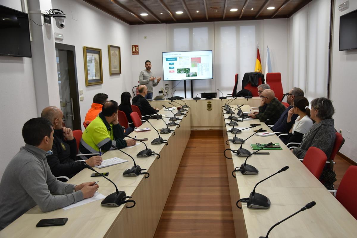 Técnico, de pie, explicando el  proyecto sobre zonas inundables a autoridades, trabajadores y voluntarios