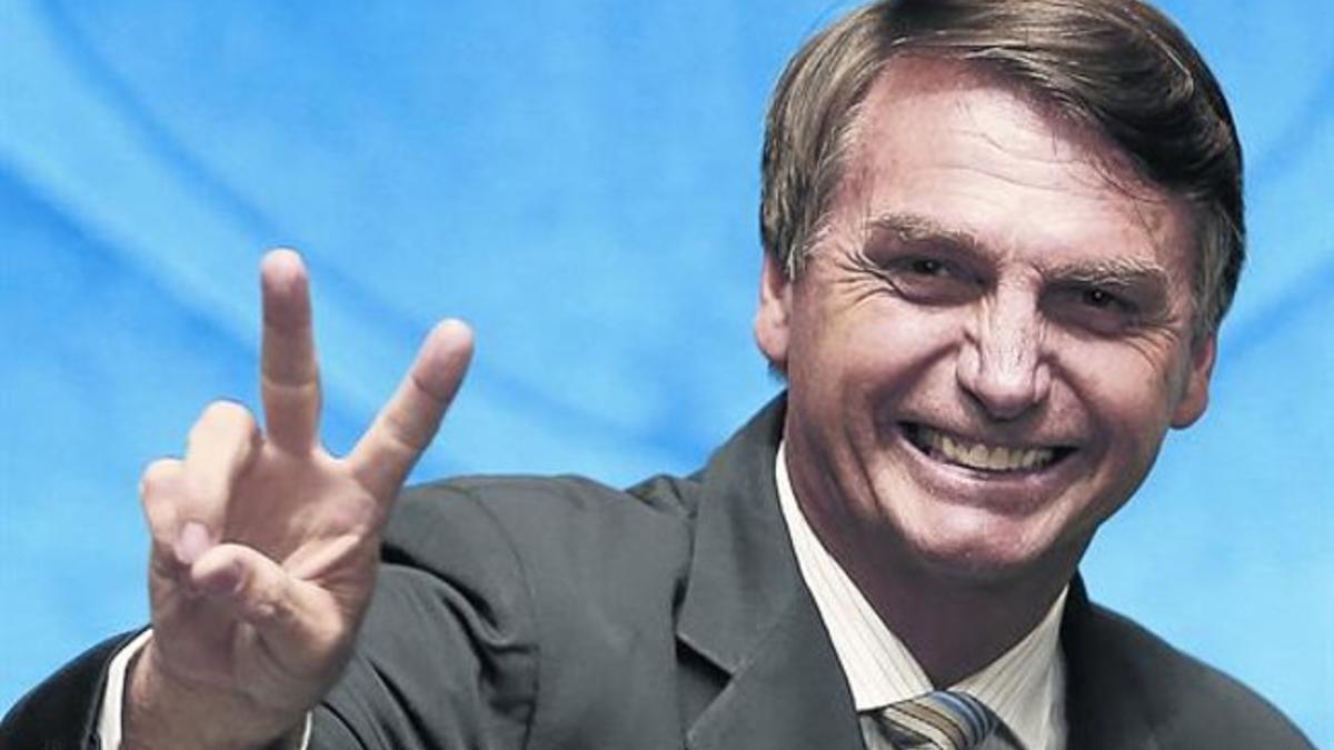 El polémico Jair Bolsonaro saluda sonriente durante un pleno del Senado brasileño, el pasado febrero, en Brasilia.