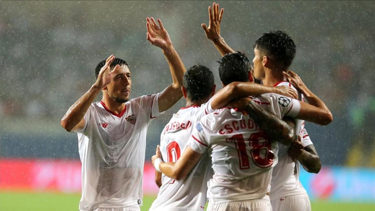 Los jugadores del Sevilla celebran bajo la lluvia el 0-1 de Escudero