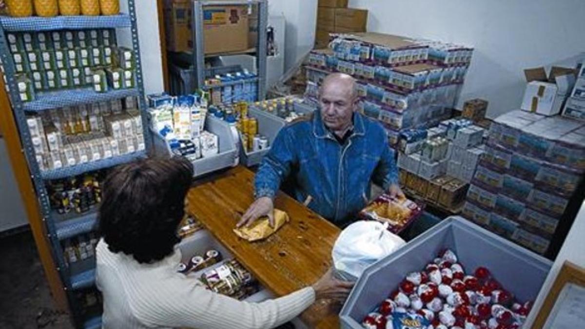 Voluntarios de Cáritas organizan el fondo de alimentos en uno de los centros de la organización en Barcelona.