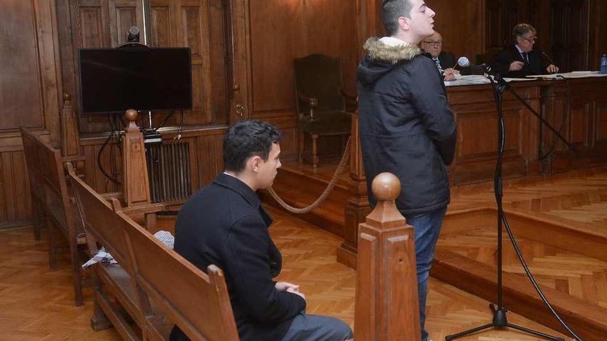 B.F.T. declara de pie, mientras A.G.A. espera sentado en el banquillo de los acusados. // R. Vázquez