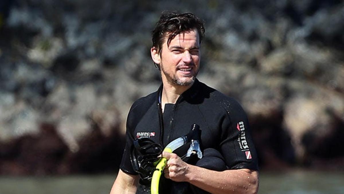 Matt Bomer saliendo del agua con su traje de neopreno y sus aletas