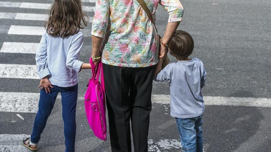 Una madre pasea con sus hijos por una calle, en una imagen de archivo.