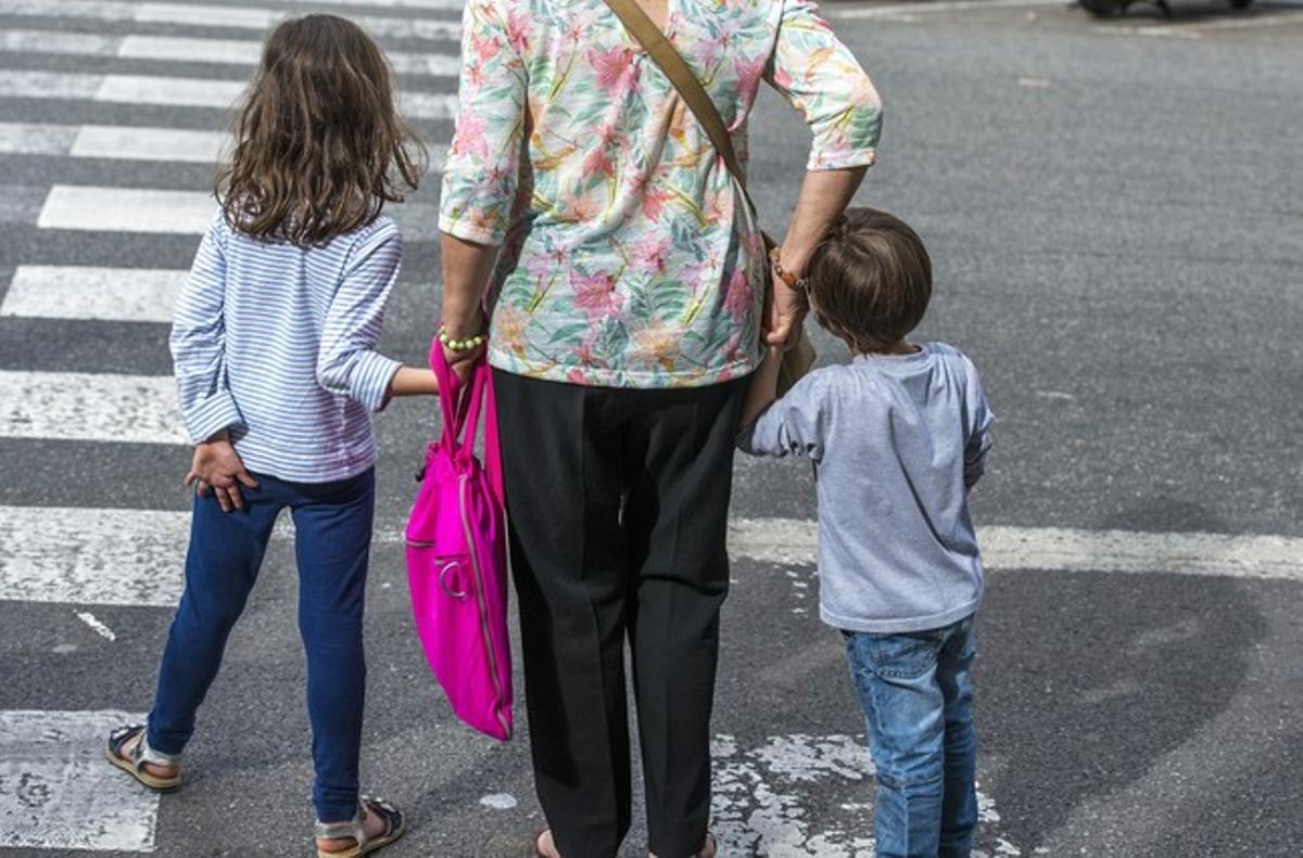 Una madre pasea con sus hijos por una calle, en una imagen de archivo.