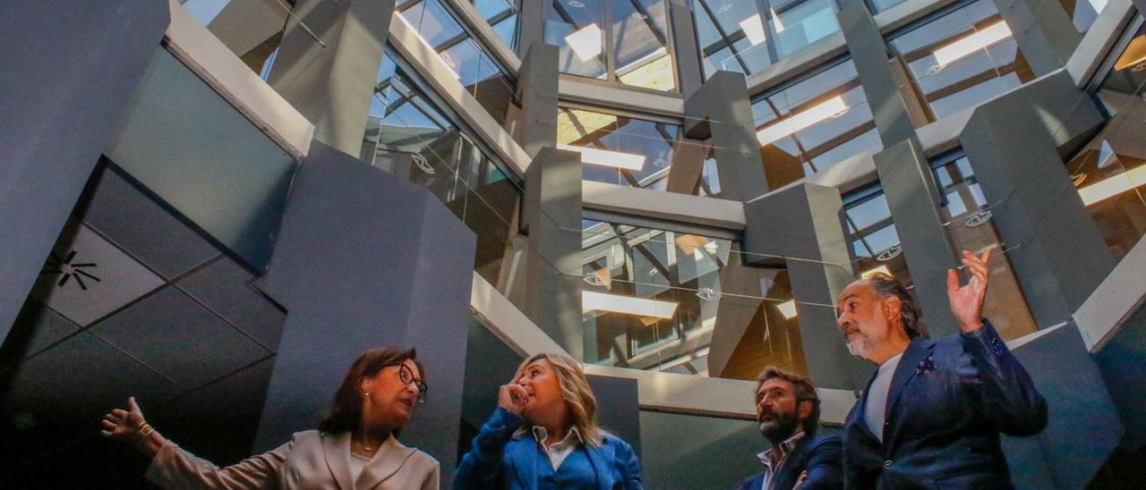 Maica Larriba, Elena Martínez y Alberto Varela, atendiendo las explicaciones del arquitecto de la obra en el hall del edificio. |