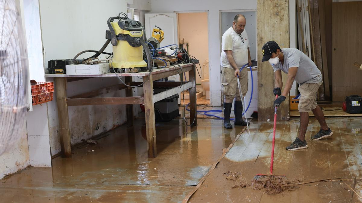 Trabajos de limpieza en un local inundado por la dana