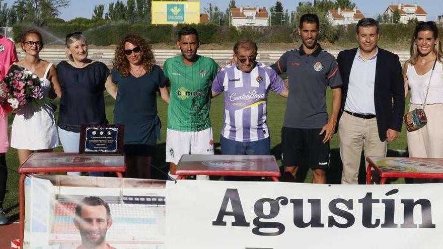 Miembros de los tres clubes y familiares de Agustín posan con la pancarta en su recuerdo.