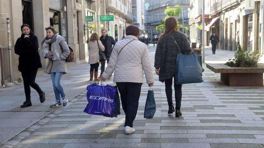 Los vilagarcianos cargan con bolsas tras las compras. //Noé Parga