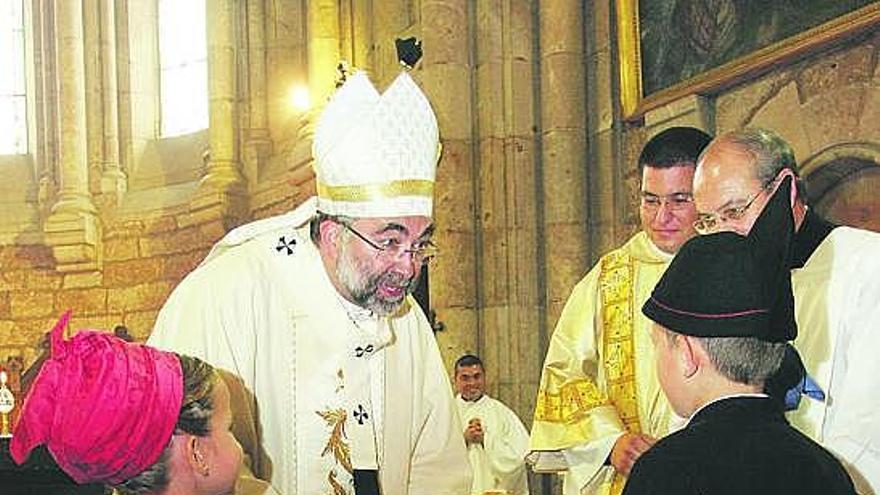 El Arzobispo, recogiendo una ofrenda de dos niños cangueses, ayer, durante la misa en la basílica de Covadonga.
