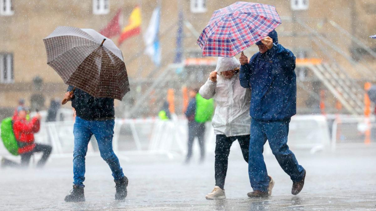 Varias personas se protegen contra la lluvia.