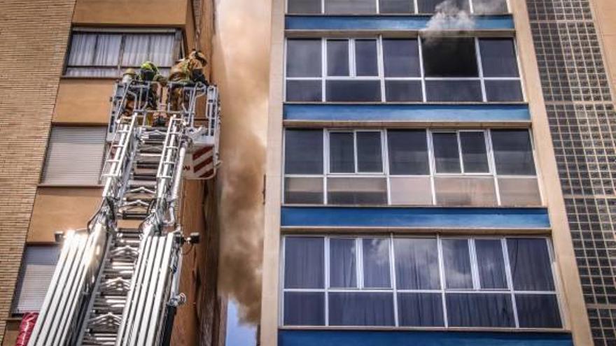 Los bomberos en plena extinción del incendio con una escalera mecánica.