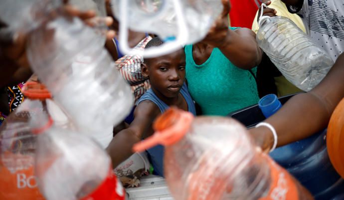 Migrantes africanos y haitianos piden agua a las m