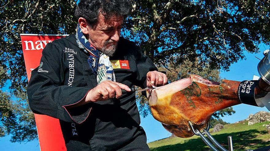 Florencio Sanchidrián corta un jamón bajo una encina. | FOTOS CEDIDAS POR NAVARRETINTO