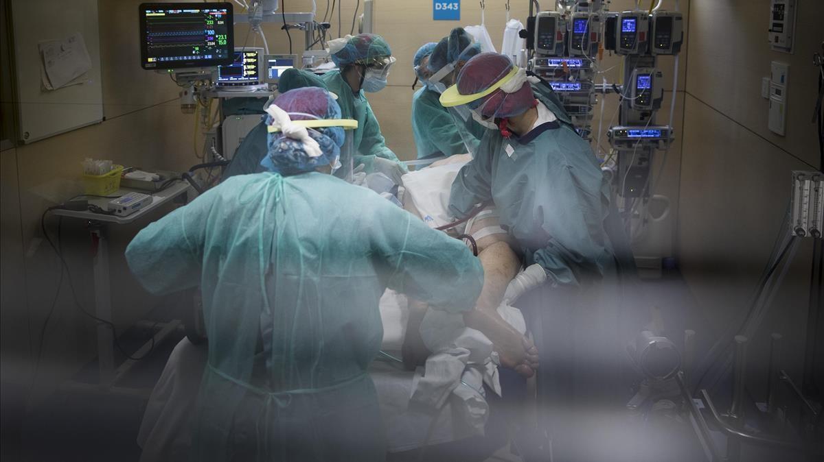 Sanitarios trabajando en condiciones durísimas, en el interior de un box del servicio de medicina intensiva en la UCI del Hospital Vall d’Hebron el día 21 de abril en Barcelona