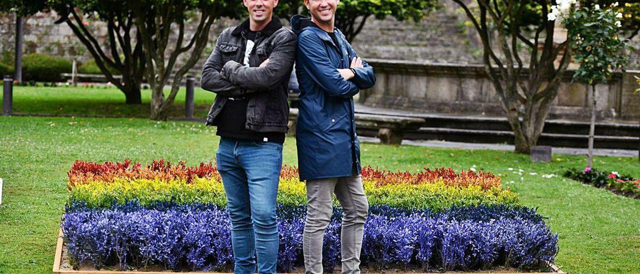 Rubén y Fernando junto al jardín que forma la bandera LGTBI+.