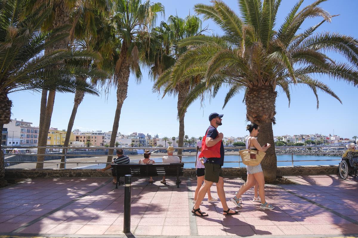 Turistas pasean por la avenida marítima de la playa de Las Marañuelas de Arguineguín.