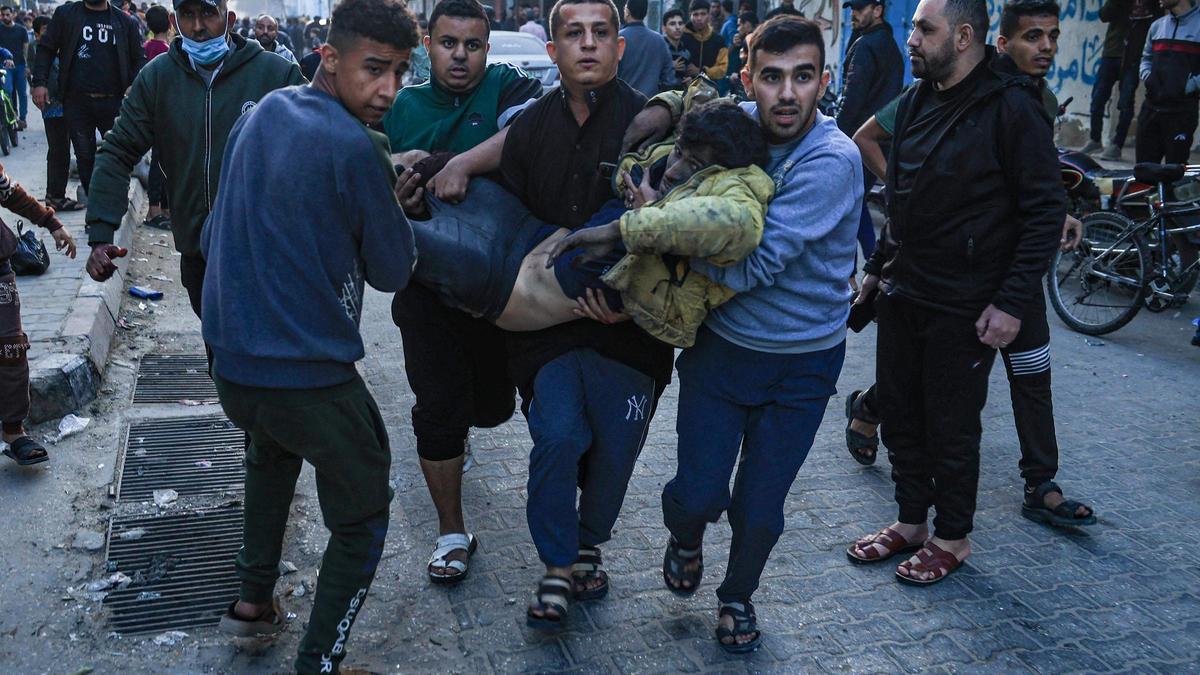 Palestinos sostienen en brazos a un herido en el sur de Gaza