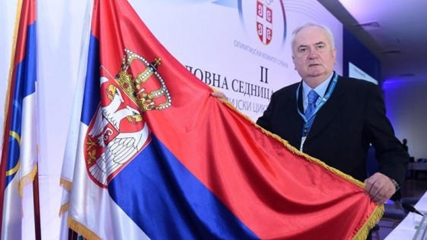 El serbio, en la actualidad, posa con la bandera de su país.