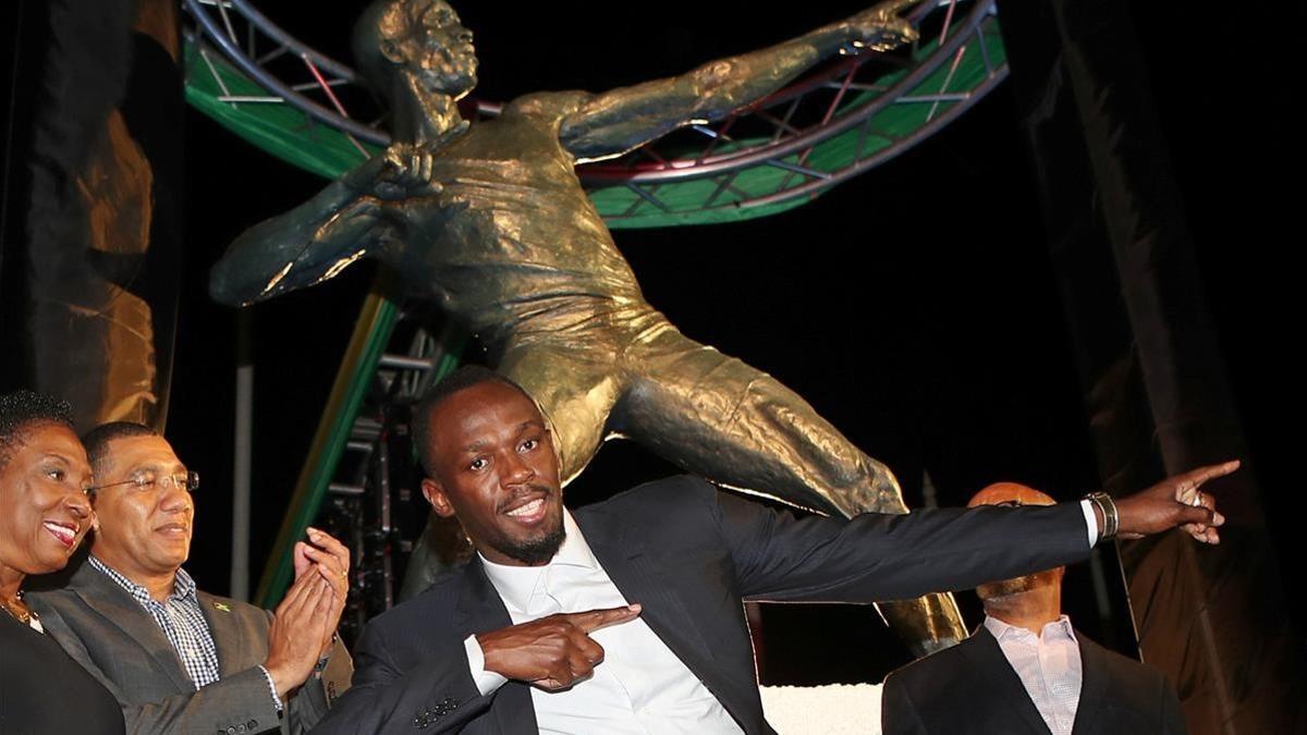 Usain Bolt, delante de su estatua en Kingston.