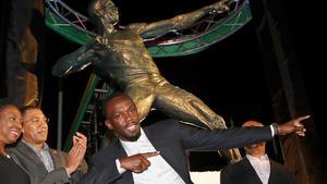 Usain Bolt, delante de su estatua en Kingston.