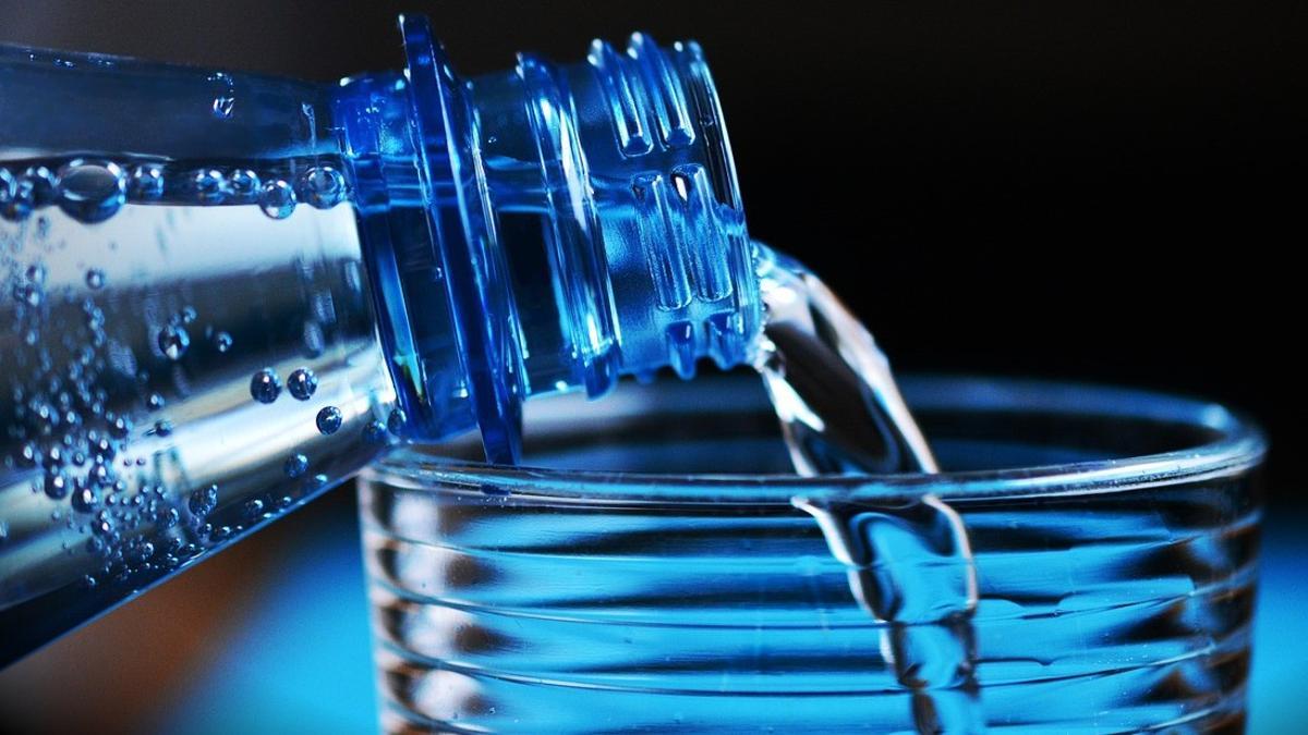 Agua embotellada vertida en un vaso.