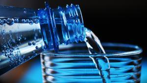 Agua embotellada vertida en un vaso.