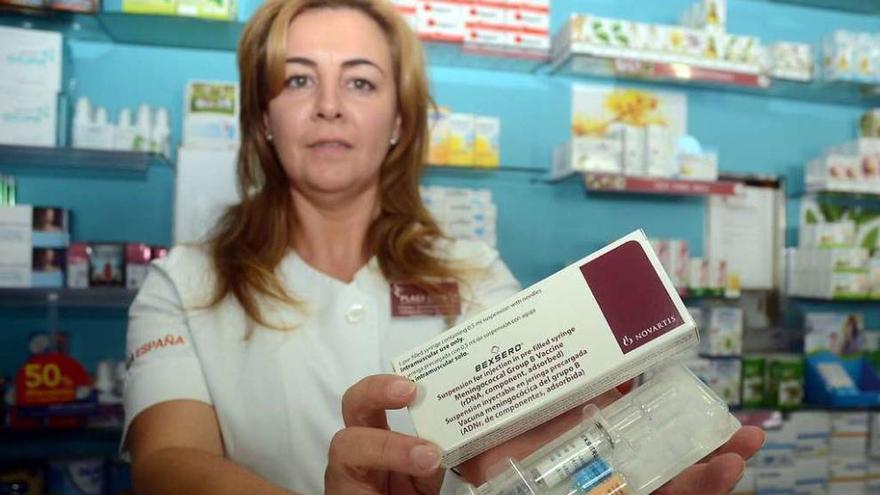 Fátima Martín, titular de la farmacia de la Praza de España, muestra la vacuna. // Rafa Vázquez