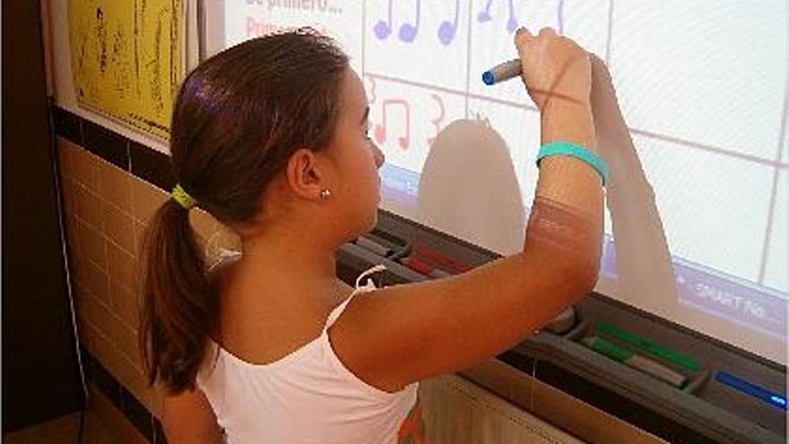 música. Una alumna trabaja ante la pizarra digital las notas utilizando un rotulador especial que se puede borrar.