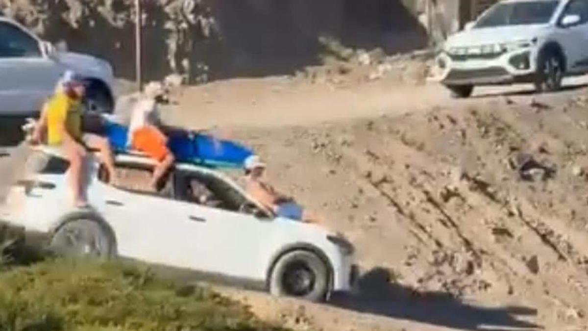 Imprudencia de turistas encima de un coche en una playa de Fuerteventura