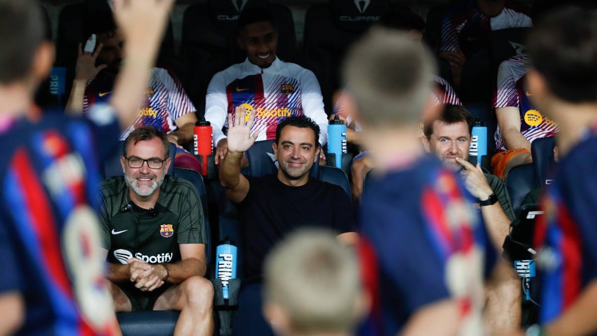 Xavi saluda desde el banquillo del Barça
