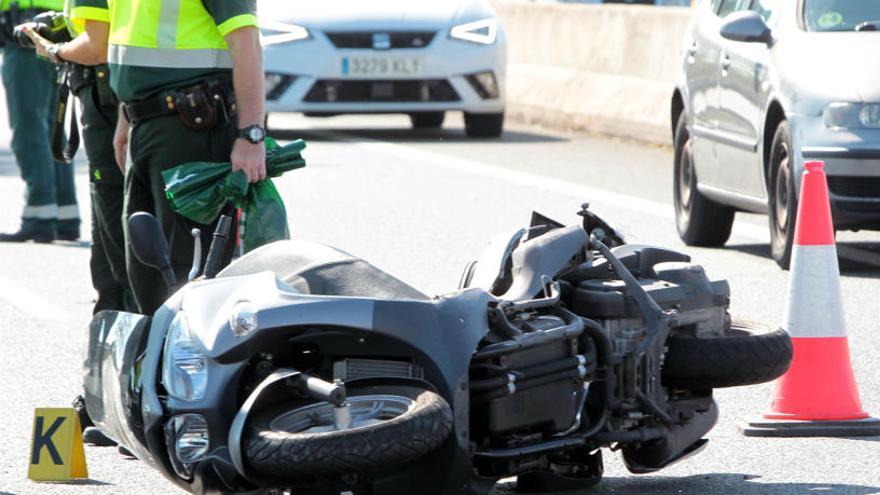 La Guardia Civil de Tráfico junto a la motocicleta de la víctima.