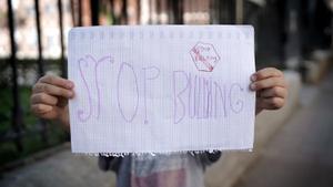 Un niño con un cartel de stop bullying.