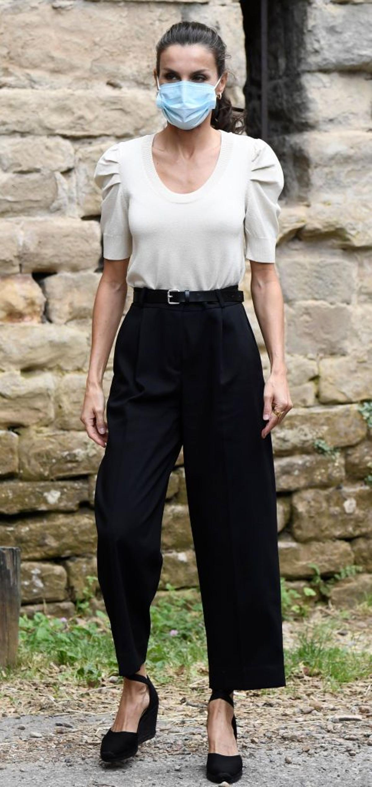 La reina Letizia con jersey blanco, pantalón negro y cuñas