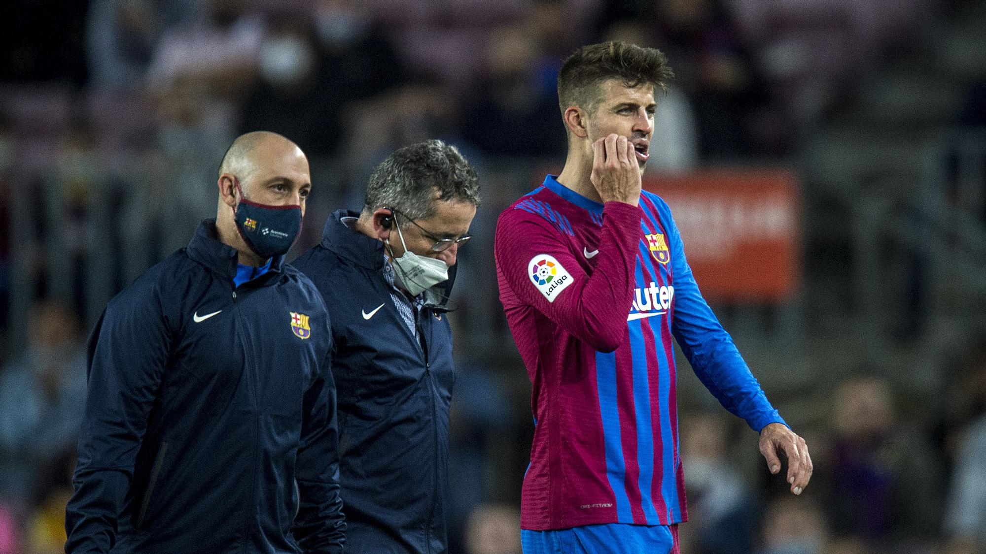 Piqué abandona el terreno de juego junto a los doctores del Barça durante el partido contra el Alavés