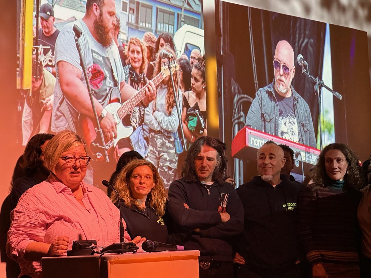 La viuda de Mario Herrero se dirige al público durante para agradecer al apoyo con las fotos de Jaime López y Mario Herrero al fondo..