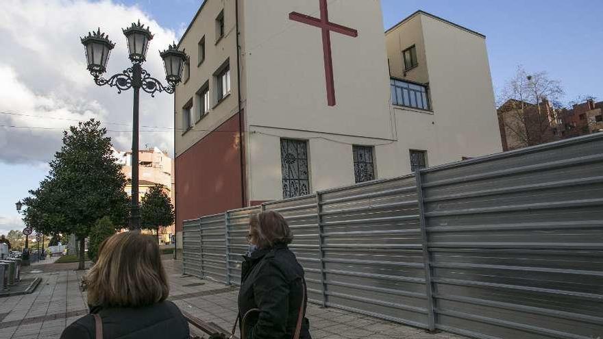Dos vecinas, ayer por la tarde, pasando junto a las vallas de las obras.