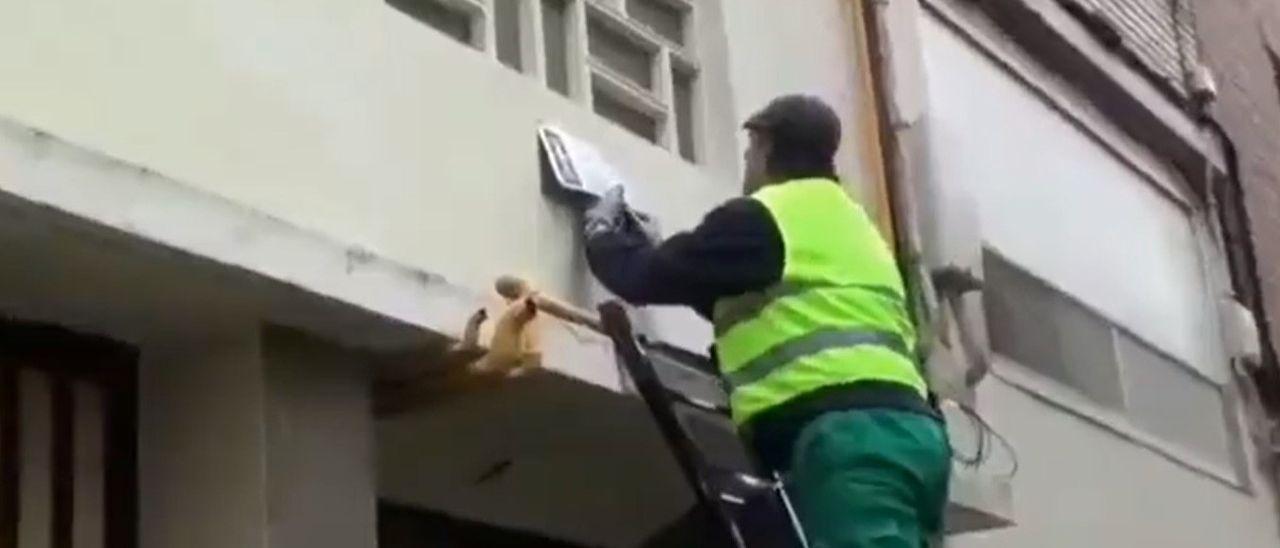 Momento de la retirada de un placa con simbología franquista en un bloque de pisos de Zaragoza.