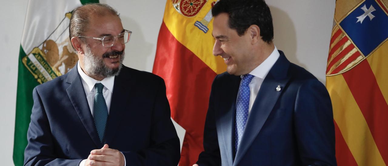 Javier Lambán y Juanma Moreno, delante de las banderas de Andalucía, España y Aragón, sonríen en un momento de la cumbre celebrada este jueves en Sevilla.