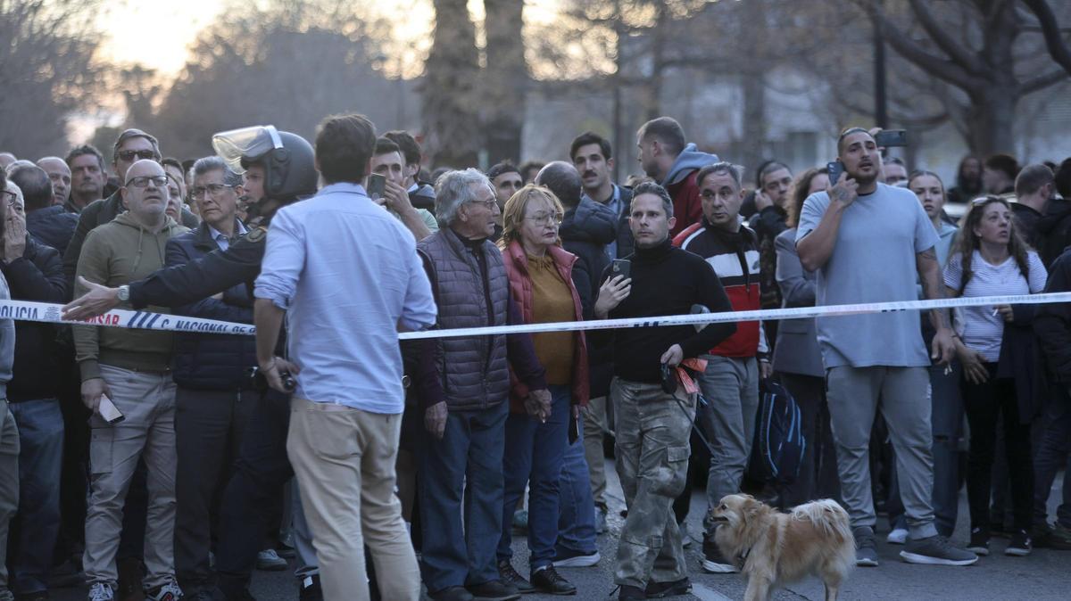 Vecinos y curiosos se agolpan en el perímetro de seguridad establecido por la Policía.