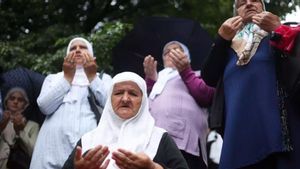 Mujeres bosnias rezan ante los restos de víctimas de la masacre de Srebrenica de 1995 y que serán enterrados este viernes en el Centro Memorial de Potocari, en Visoko
